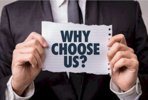 someone in a suit holding a piece of paper that reads "Why Choose Us?"