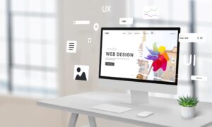 Computer display on a work desk featuring a web design studio page with floating website creation modules, surrounded by empty space for advertising text – ideal for showcasing digital design